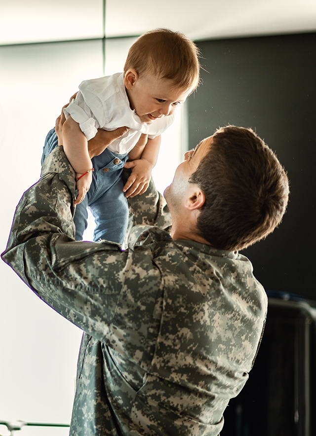 happy-baby-boy-having-fun-with-his-military-dad-home-mother-is-background 1.png